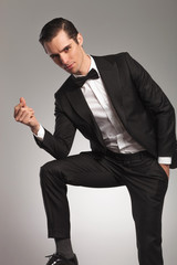 elegant man in tuxedo snapping finger
