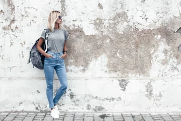 Model posiert im schlichten T-Shirt an der Straßenmauer © Alena Ozerova