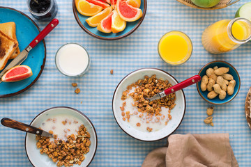 Muesli with yogurt, bread toasts, milk, orange juice and fruits