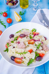 Pasta salad with tuna, olives, cherry tomatoes and arugula