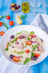 Pasta salad with tuna, olives, cherry tomatoes and arugula