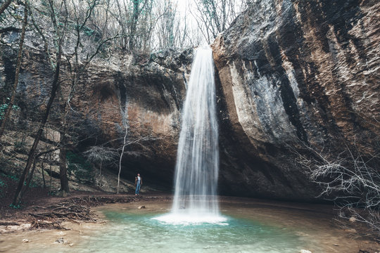 Human standing by the waterfall