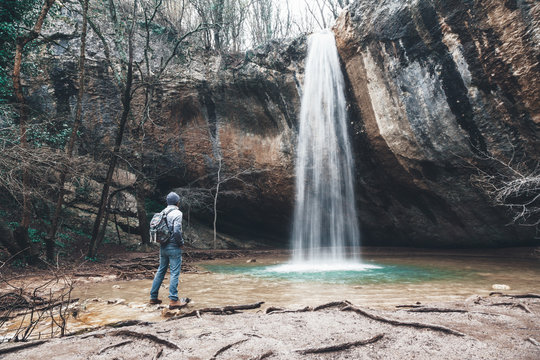 Human standing by the waterfall