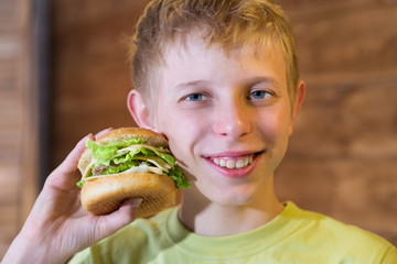 A teenager eating a sandwich