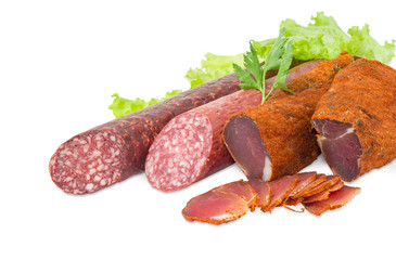 Dried pork tenderloin and two different varieties of sausages closeup
