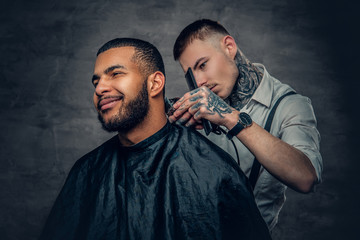 Male barber cutting the beard to Black stylish man.