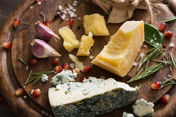 Obraz na płótnie Canvas Cheese delikatessen closeup on rustic wood, blue roquefort and parmesan