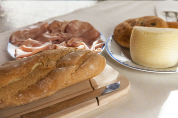 Top view of loaf of bread, with cheese and mortadella sausage. Italian food, breakfast time
