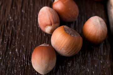 Obraz premium Hazelnut on brown wooden background. Close up.