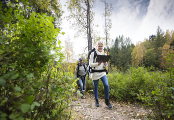 Young Woman Holding Map While Hiking With Friend