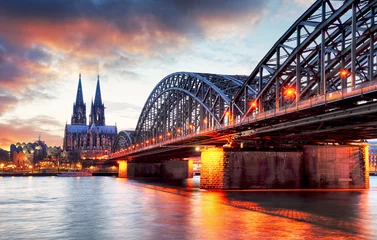Fotobehang Bruggen Dom van Keulen en Hohenzollern-brug bij zonsondergang - nacht