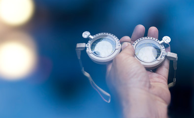 hands holding optical instrument.