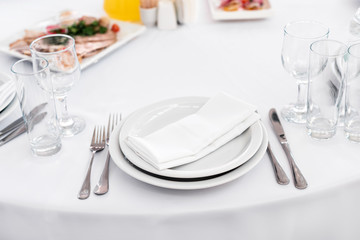 Empty plate on the table, cutlery set. Table appointments