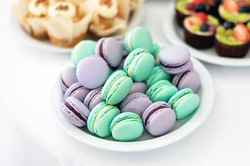Turquoise and violet macarons. Wedding cakes on the table. Sweet desserts. Selective focus