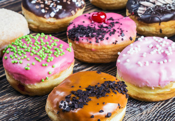 Glazed donuts with different fillings on a wooden table