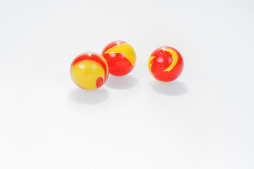 Three red yellow marbles isolated on white background