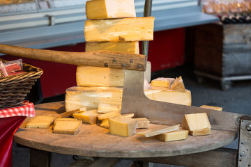 Cheese for sale and an old cutter or chopper used for slicing cheeses in a market at Salzburg...