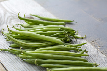 Bunch of green beans on the wooden background