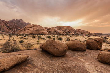 Round stones in the Namibian savanna at sunset
