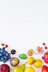 Fototapeta na wymiar Rainbow colored fruits over white background. Healthy eating / diet. Juice and smoothie ingredients. Copy space.