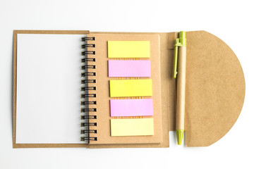 Notebook paper and a pen on white background.
