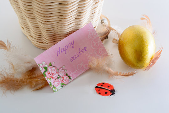 Happy easter card, gold egg, ladybug and feathers
