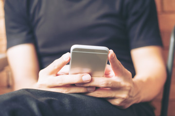 A man holding and using smart phone in modern cafe