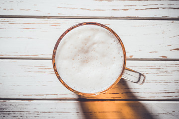 Glass of beer on white wooden background