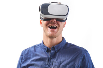 Amazed young man looking in a VR goggles with open mouth tudio shot on white background.
