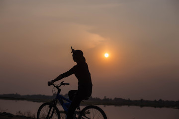 Fototapeta na wymiar Woman biking hands at sunset. 