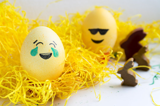Happy easter: 2 emoji as easter egg in yellow gras with bunny - tears of joy and sunglasses
