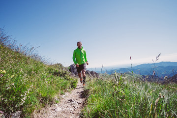 Man trail running on a mountain in summer