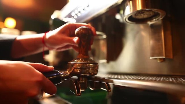 Close up shot of a barista preparing an espresso coffee in a bar. 