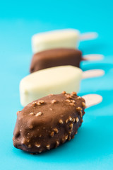 Chocolate ice cream popsicles isolated on blue background. 
