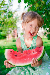 Happy little blonde girl with big slice watermelon in summer time in park, outdoor. Smiling. Happy.