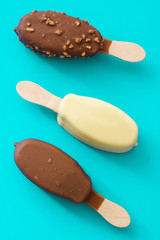 Chocolate ice cream popsicles isolated on blue background. 
