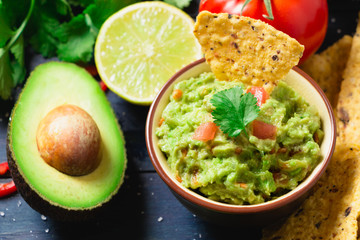 Guacamole with ingredients and tortilla chips - obrazy, fototapety, plakaty