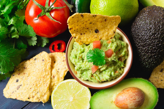 Guacamole with ingredients and tortilla chips