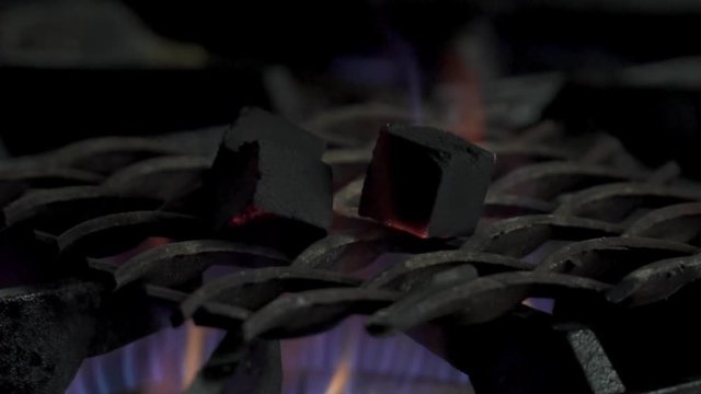 Closeup of burning coals for hookah in the kitchen, slow motion