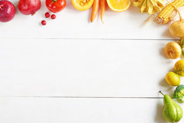 Rainbow colored fruits and vegetables frame over white table. Healthy eating / diet. Juice ingredients. Copy space.