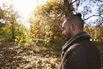Young Man Walking In Autumn Woodland