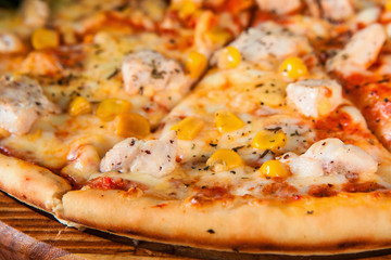 Baked italian pizza sliced and served on wooden platter, close up view. Restaurant menu photo, appetizing food background