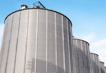 Agricultural silos on blue sky.