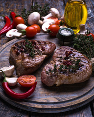  Beef Steak, salt, pepper, garlic, rosemary, olive oil  on the black wooden board, background.
