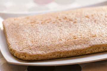 Close up shot of tasty biscuit on plate with small piece cut.