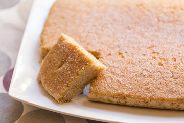 Close up shot of tasty biscuit on plate with small piece cut.