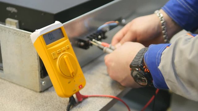 Engineer working with multimeter in laboratory. 4K.