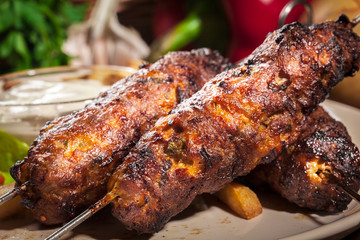 Grilled shish kebab served with fried chips and salad