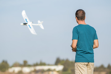 Man with remote control plane flying in air - 141347893