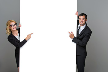 Businessman and business woman with big empty poster